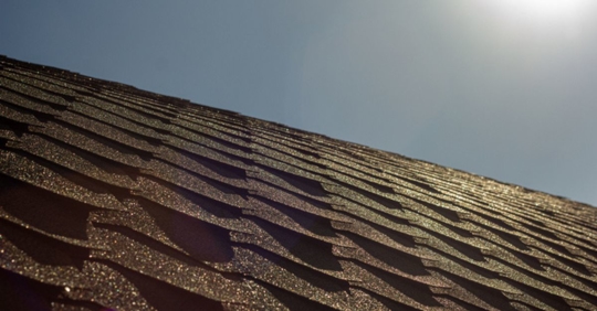 sun shining over shingle roof